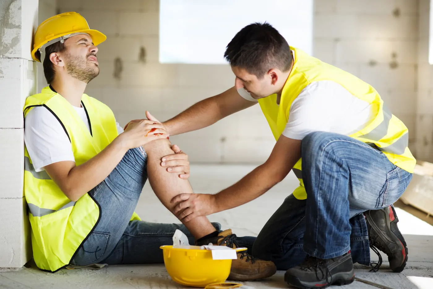 Trabajador lesionado recibiendo ayuda en una obra